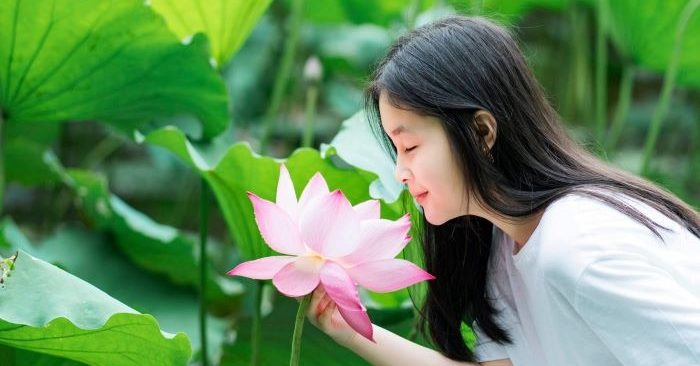 Người phụ nữ hạnh phúc khi cảm nhận được mùi thơm của hoa sen