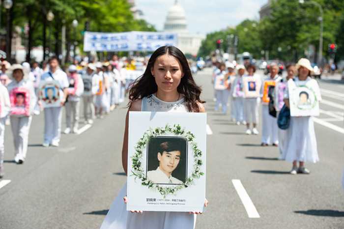 Một người cầm di ảnh của một học viên Pháp Luân Công bị chính quyền ĐCSTQ bức hại đến chết trong một cuộc diễu hành tại Washington DC ngày 17/7/2014