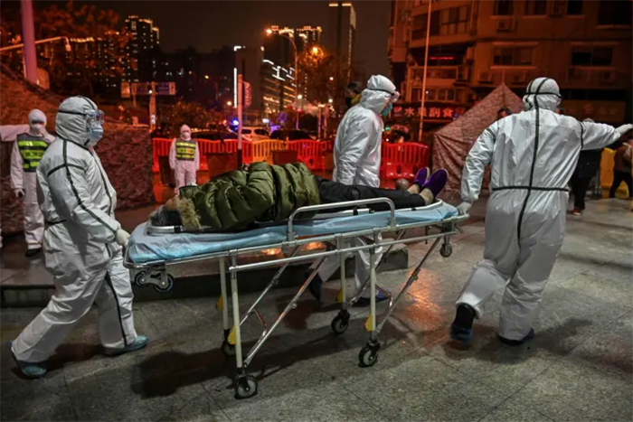 Nhân viên y tế vận chuyển một bệnh nhân đến bệnh viện Vũ Hán vào tháng 1 năm 2020, trong giai đoạn đầu của đợt bùng phát dịch