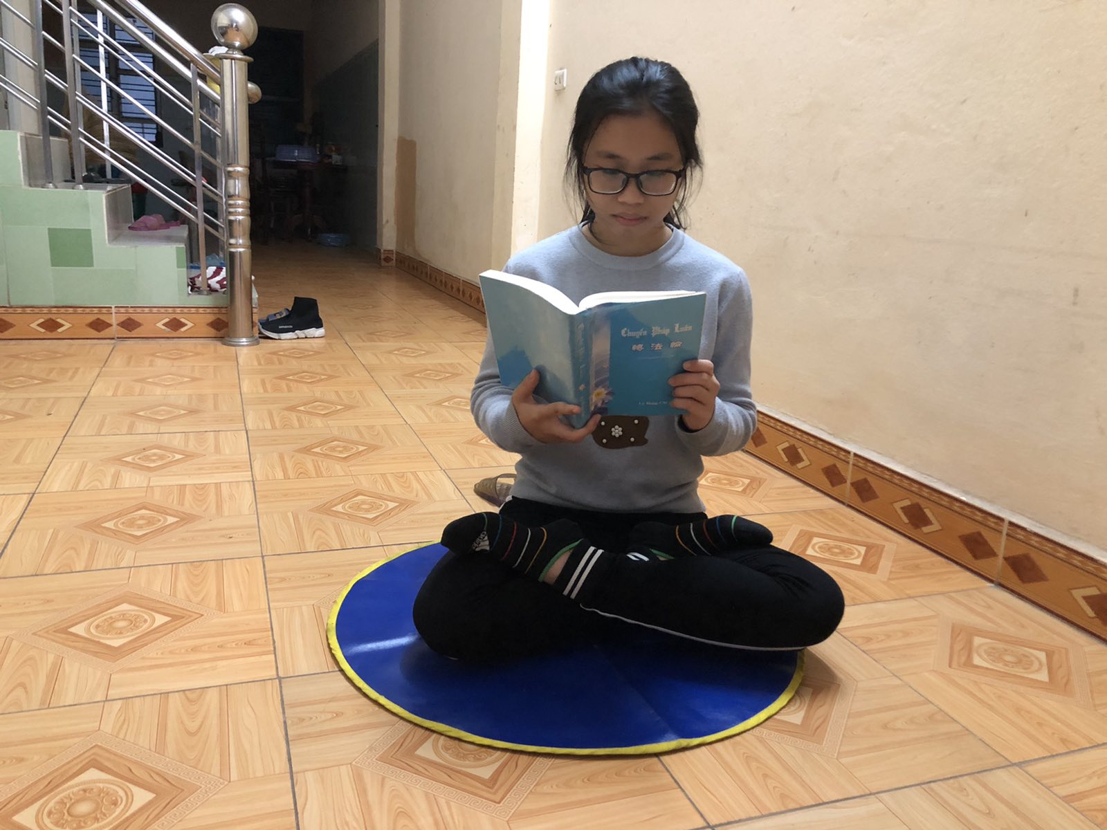 Quỳnh Hương đang đọc cuốn sách Chuyển Pháp Luân.