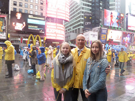 Ông Werner Kleinert cùng hai cô con gái Indra (bên trái) và Mira cùng tham gia sự kiện mừng ngày Pháp Luân Đại Pháp thế giới năm 2017, được tổ chức tại Quảng trường Thời Đại, thành phố New York, Mỹ, ngày 13/5/2017 (ảnh: The Epoch Times).