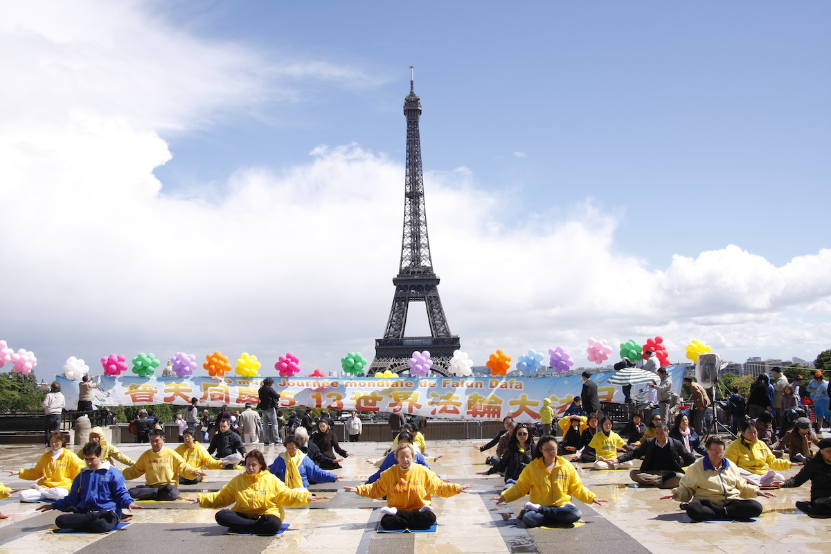 Các học viên Pháp Luân Công ngồi thiền tại Quảng trường Nhân quyền, gần Tháp Eiffel, thủ đô Paris, Cộng hòa Pháp vào ngày Pháp Luân Đại Pháp thế giới 13/5/2014 (ảnh: Minh Huệ).