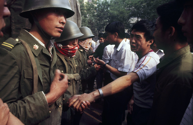Cư dân Bắc Kinh cố gắng bảo vệ các sinh viên bằng cách chặn đường tiến của xe quân sự và cố gắng thuyết phục các binh lính rút lui, vào khoảng ngày 25/5/1989 (ảnh: Liu Jian).